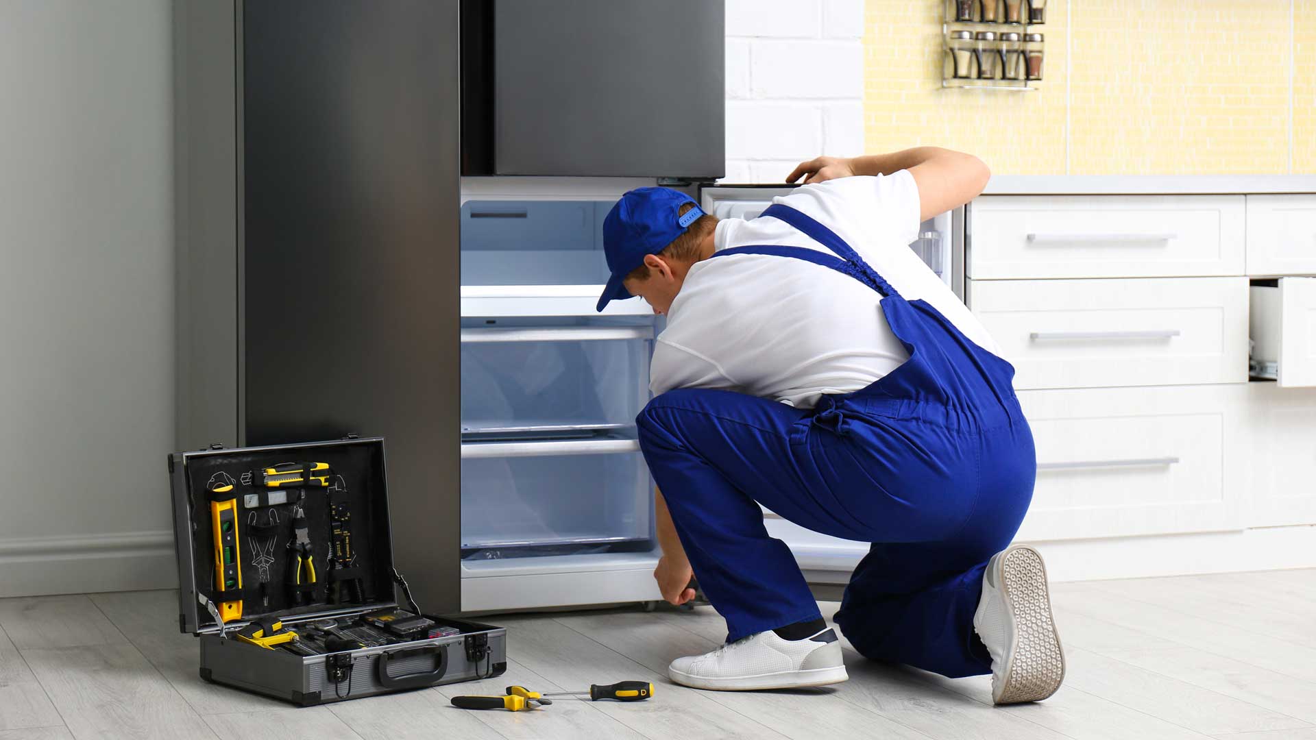Appliance repair technician repairing the freezer drawer on a refrigerator